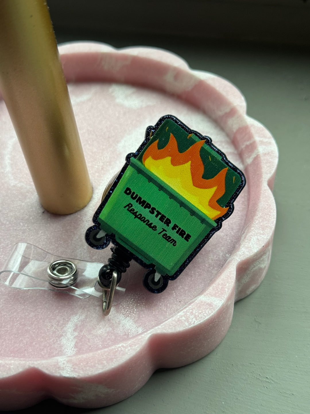 Ladyspinedoc x Dr. Beachgem Dumpster Fire Response Team Badge Reel - Retractable with Alligator Clip, displayed in pink tray.