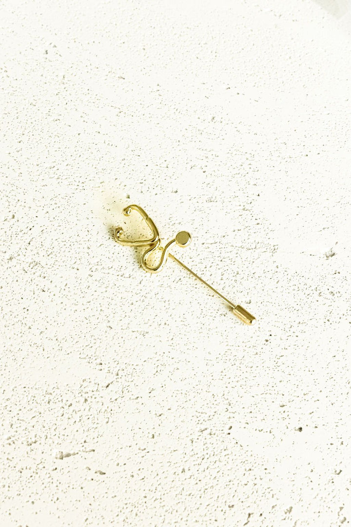 Gold Stethoscope Jacket Lapel Pin on a white surface