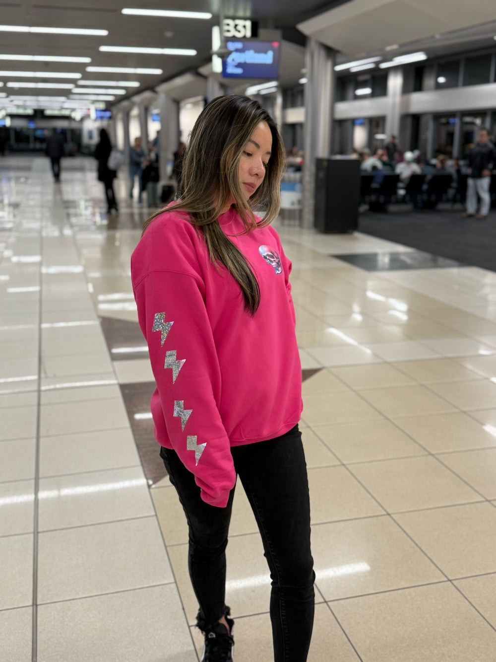 Model showing off the prismatic lightning bolts of The Power Within Crewneck Sweatshirt - Pink Shirt with Lightning Bolts, Skull, and Motivational "BE THE ENERGY YOU WANT TO ATTRACT" Motto