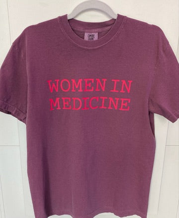 Burgundy t-shirt with 'WOMEN IN MEDICINE' text in pink on a white background