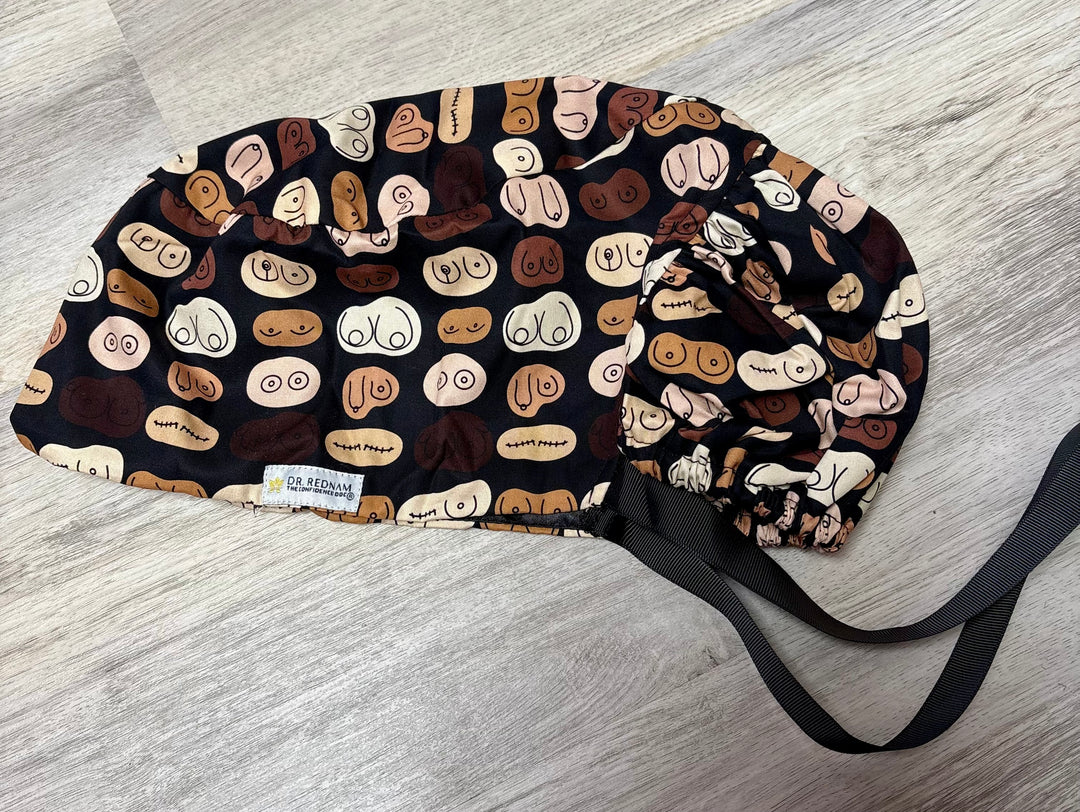 Scrub hat featuring a bold, anatomical breast print in diverse skin tones and shapes, designed by Dr. Rukmini Rednam (The Confidence Doc) in collaboration with Ladyspinedoc.