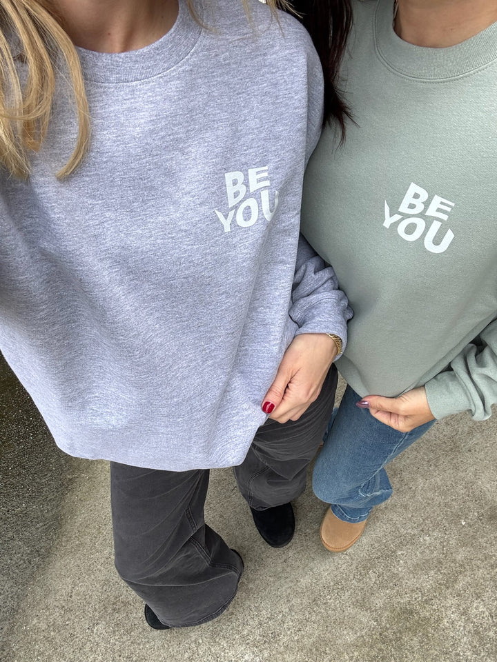 Two Woman standing side by side wearing BE YOU Crewneck Sweatshirt in gray and sage green