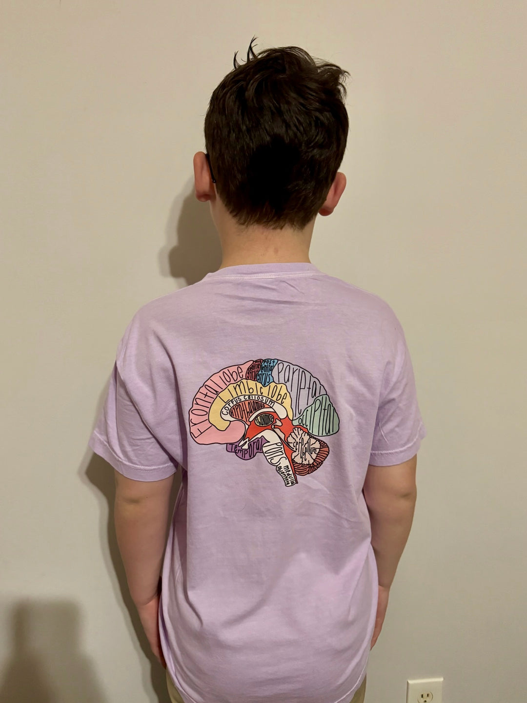 Youth showing off the back of the purple "I Lobe You" Brain Anatomy Tee with labeled parts of the brain
