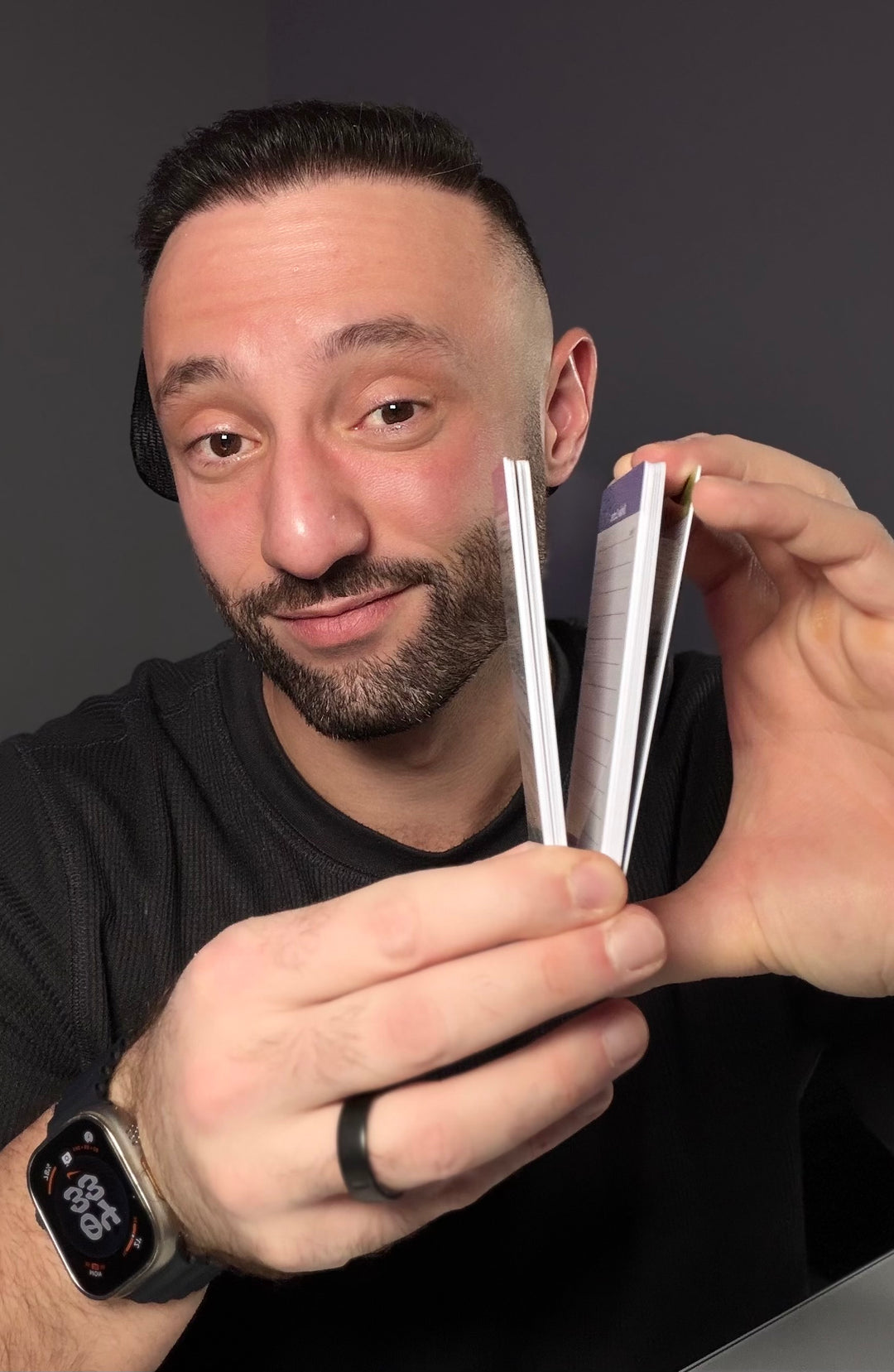 Dr. Z holding scrub cards against a dark background