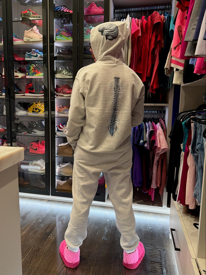 Ladyspinedoc in her cerebrospinal hoodie with pink shoes standing in front of a walk-in closet filled with shoes and clothing.