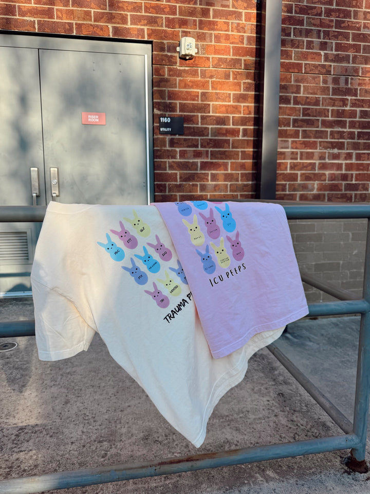 The Trauma Squad and ICU Squad tee shirts displayed on a metal railing. 