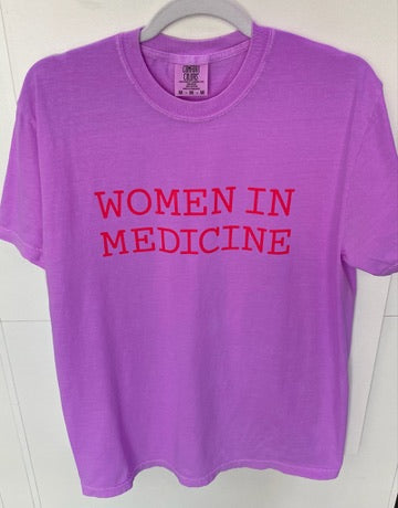 Purple t-shirt with 'WOMEN IN MEDICINE' text on a white background