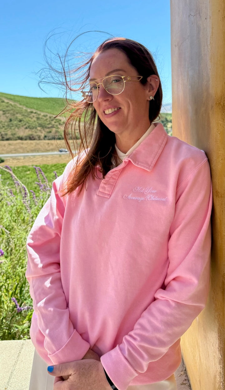 Ladyspinedoc wearing the 'Not Your Average Whitecoat' Pink Polo Collar Sweatshirt, standing outdoors against a wooden post.