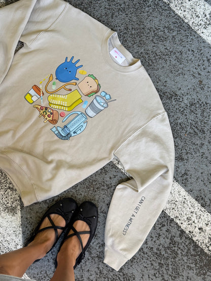 Flat lay of beige Nurse Sweatshirt with  nurse memorabilia graphics on the front. 