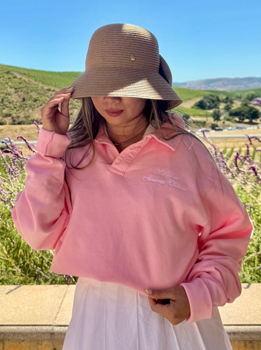 Woman wearing the Not Your Average Whitecoat Pink Polo Collar Sweatshirt and a brown hat outdoors.