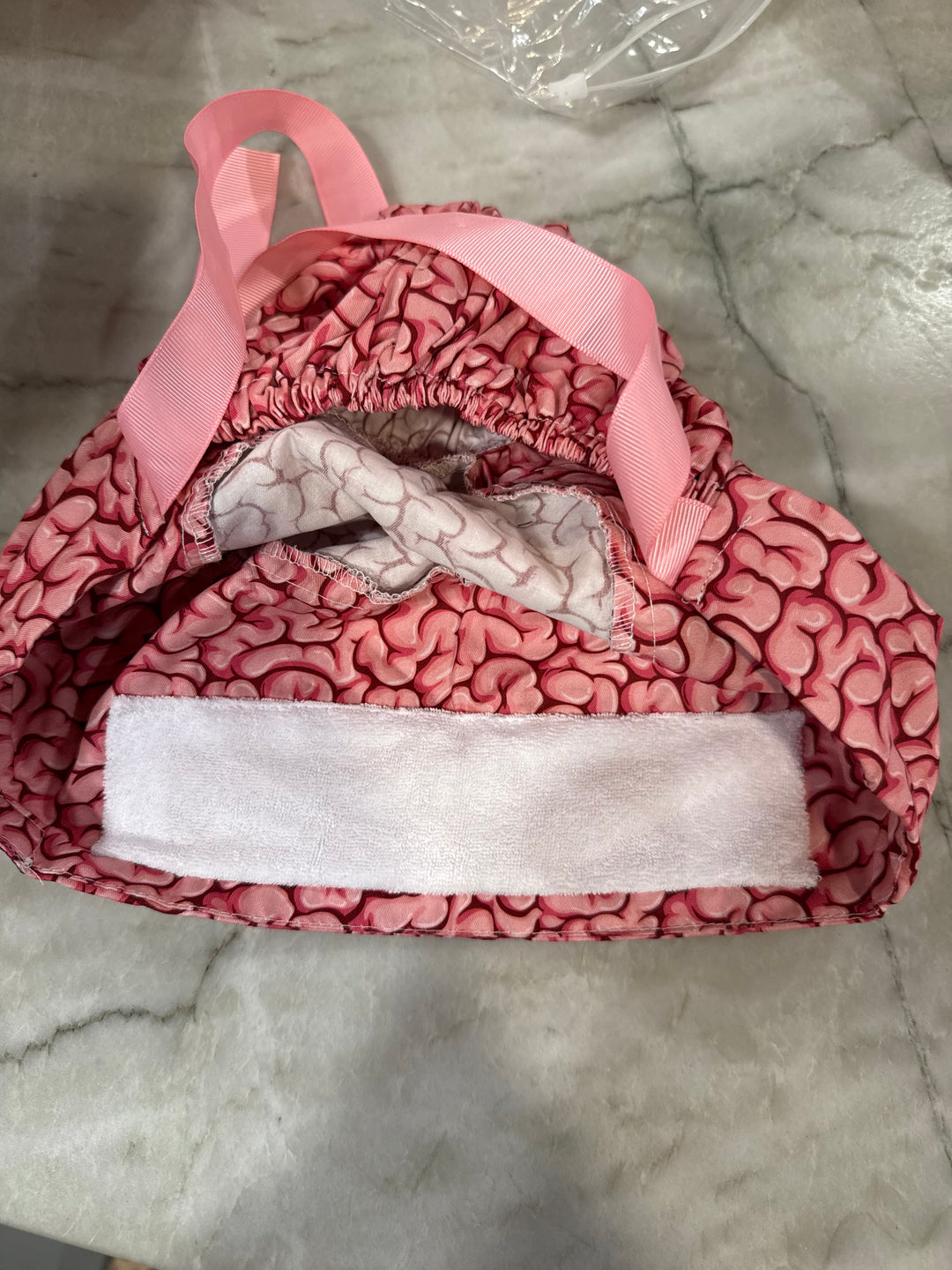 Flat lay of the opening of the Cortex Cap - Pink Scrub Hat with Brain Design showing the small sweatband inside
