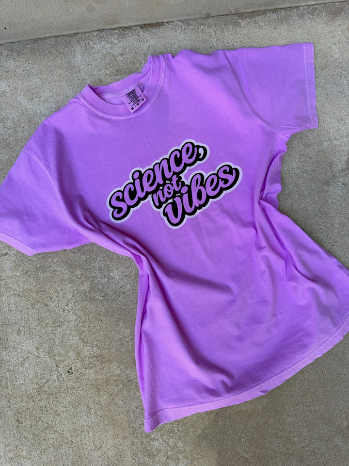 Purple t-shirt with 'Science, not vibes' text on a concrete floor