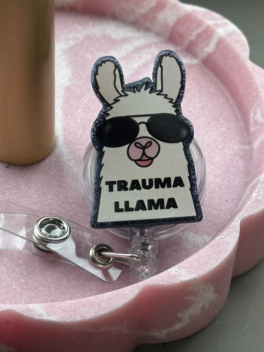 Sparkly Trauma Llama Badge Reel with llama wearing sunglasses and Trauma Llama saying at the base. 