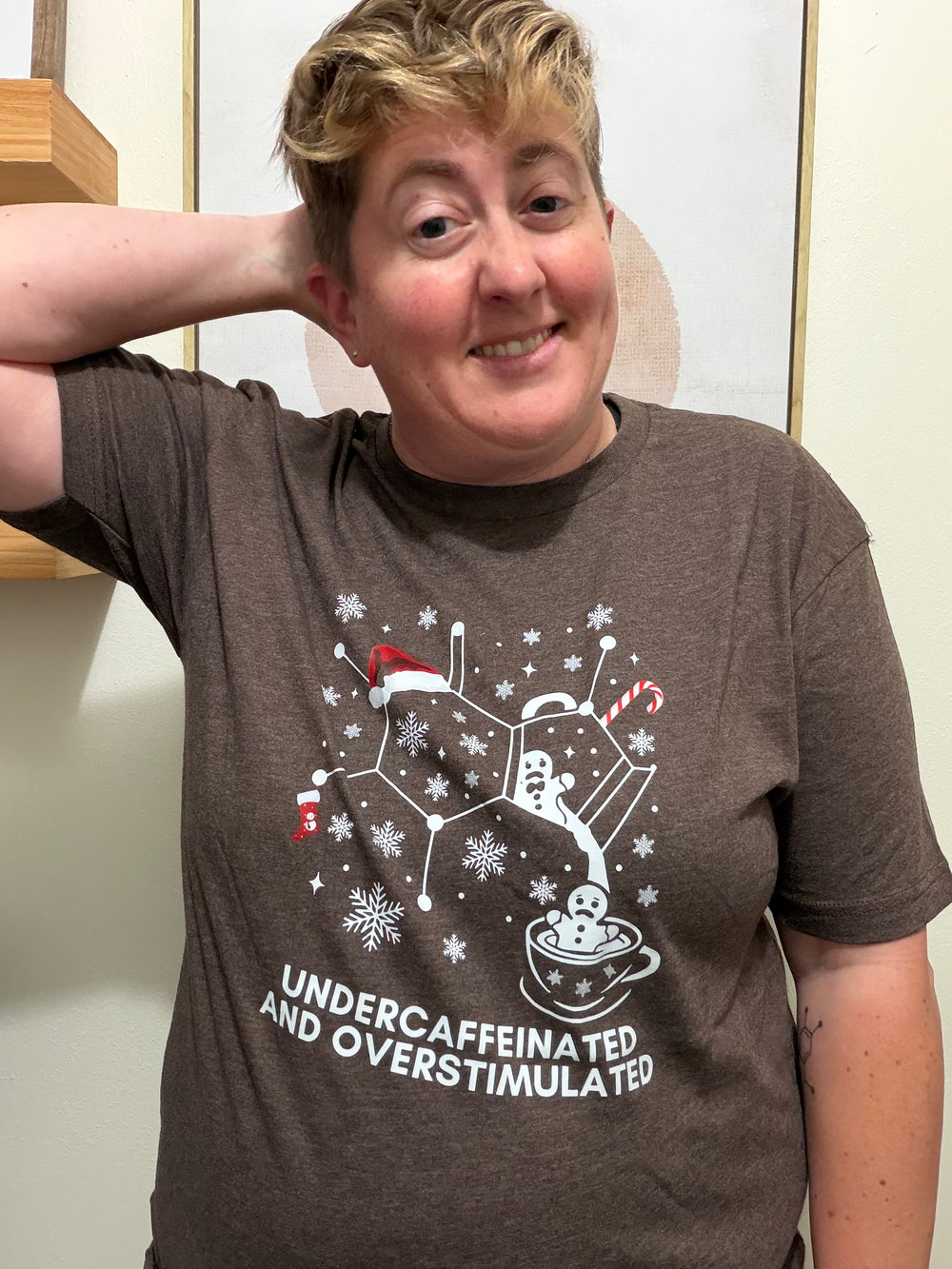 Dr. Beachgem wearing a brown "undercaffeinated and overstimulatedt" shirt with a holiday graphic design