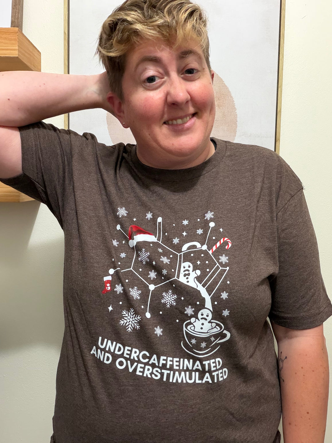 Dr. Beachgem wearing a brown "undercaffeinated and overstimulatedt" shirt with a holiday graphic design
