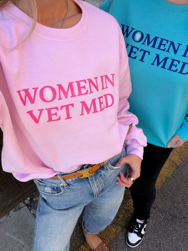 Two people wearing sweatshirts with 'WOMEN IN VET MED' text.