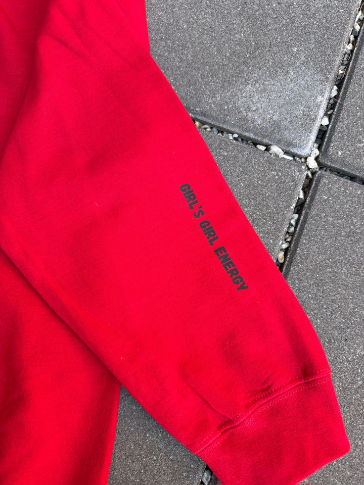Red sweatshirt with Girl's Gilr Energy text on a gray pavement