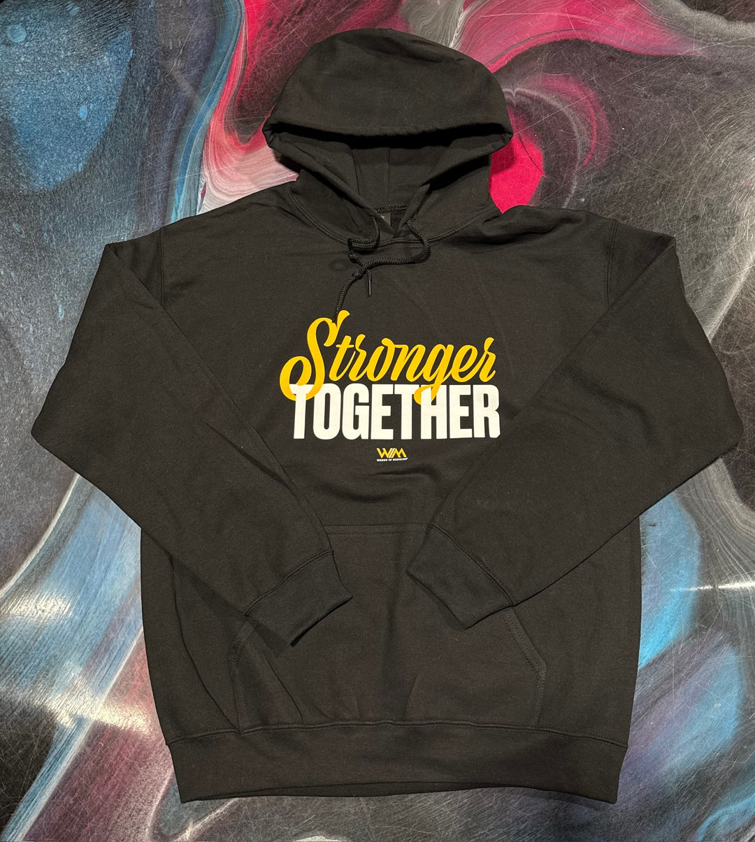 Flat lay of black hoodie with 'Stronger Together' text on a colorful abstract background