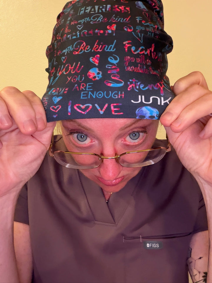 Dr. Betsy Grunch (Ladyspinedoc) wearing Be You (Positive Affirmations) Junk Brands Scrub Cap and a brown scrub top.