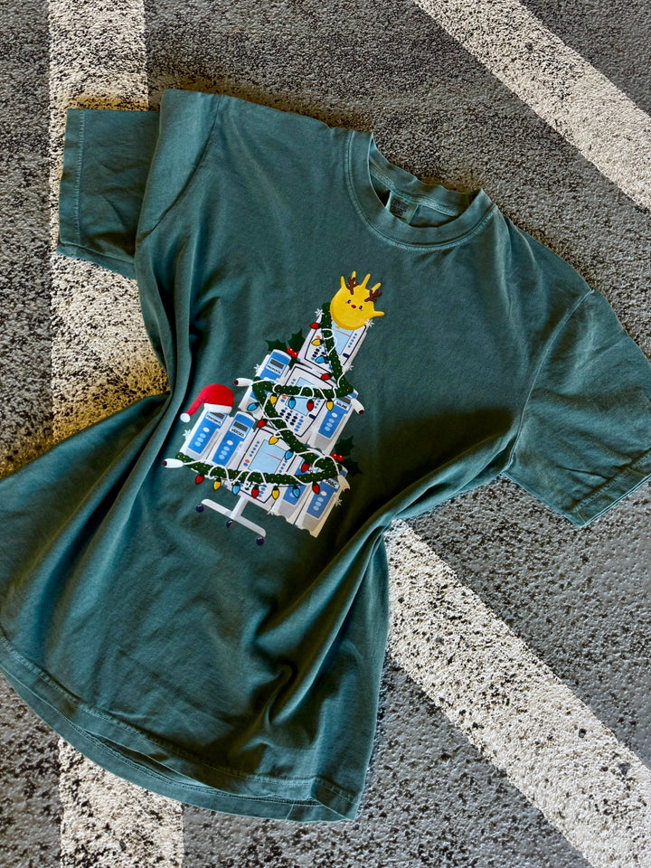 Green Nurse Christmas Tree Tee Shirt with IV Pump Design on a textured surface