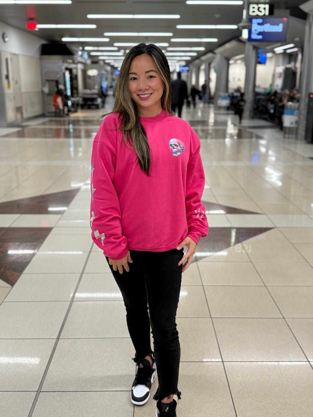 Model wearing The Power Within Crewneck Sweatshirt - Pink Shirt with Lightning Bolts, Skull, and Motivational "BE THE ENERGY YOU WANT TO ATTRACT" Motto
