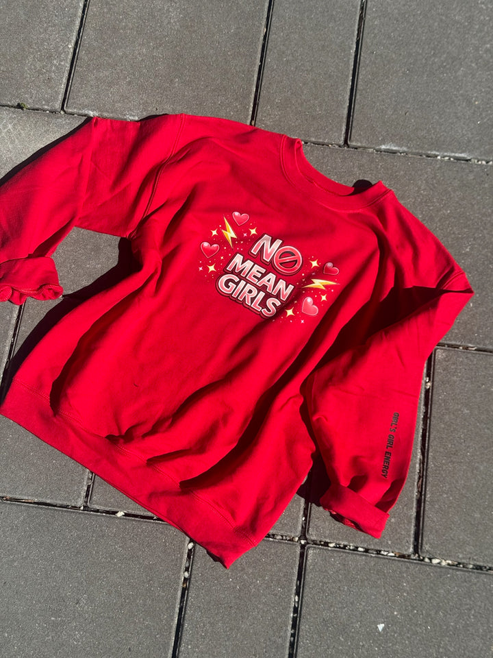 Red sweatshirt with 'No Mean Girls' text on a gray pavement