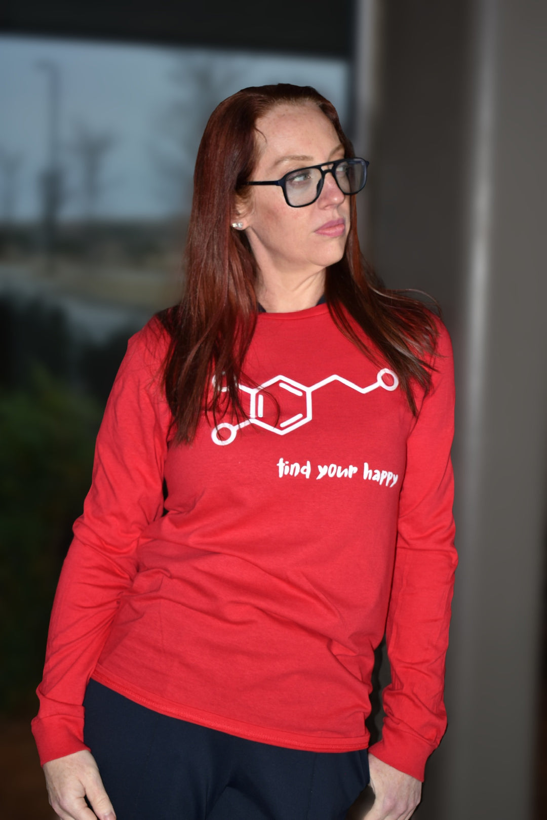 Dr. Betsy Grunch - Ladyspinedoc - wearing a red long-sleeve t-shirt featuring a white dopamine molecule on the front with the phrase “find your happy” below in a playful brush font.