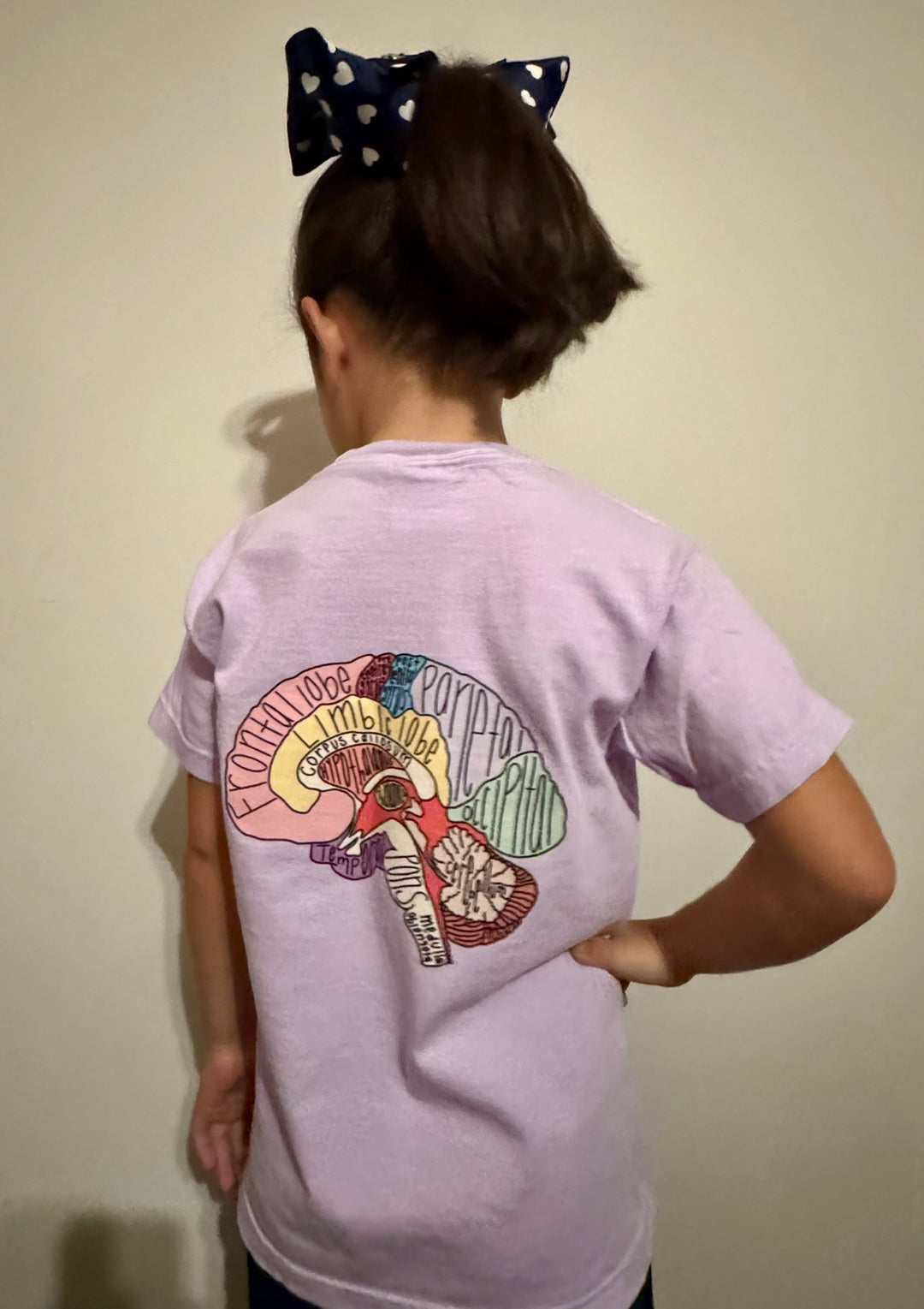 Girl showing off the back of the purple "I Lobe You" Brain Anatomy Tee with labeled parts of the brain