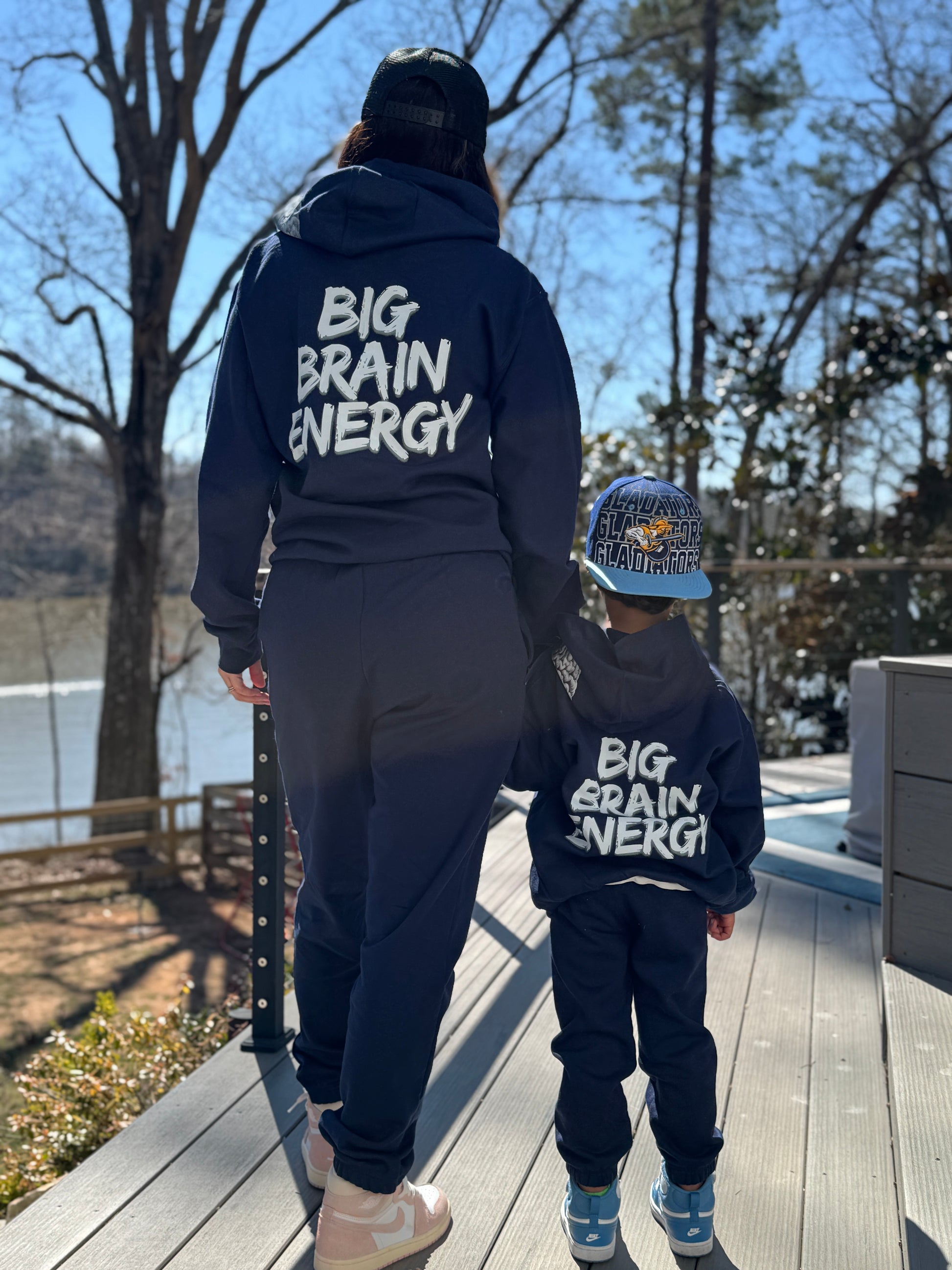 Adult and youth wearing Navy hoodie with "BIG BRAIN ENERGY" printed in bold white capital letters across the back.