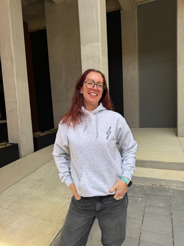 Dr. Betsy Grunch - Ladyspinedoc wearing the BIG BRAIN ENERGY light gray hoodie with the hood up, showcasing the brain design on the left side of the hood.
