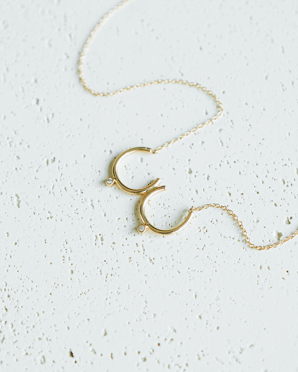 Flat lay of gold Bust Necklace with Diamond Nipples