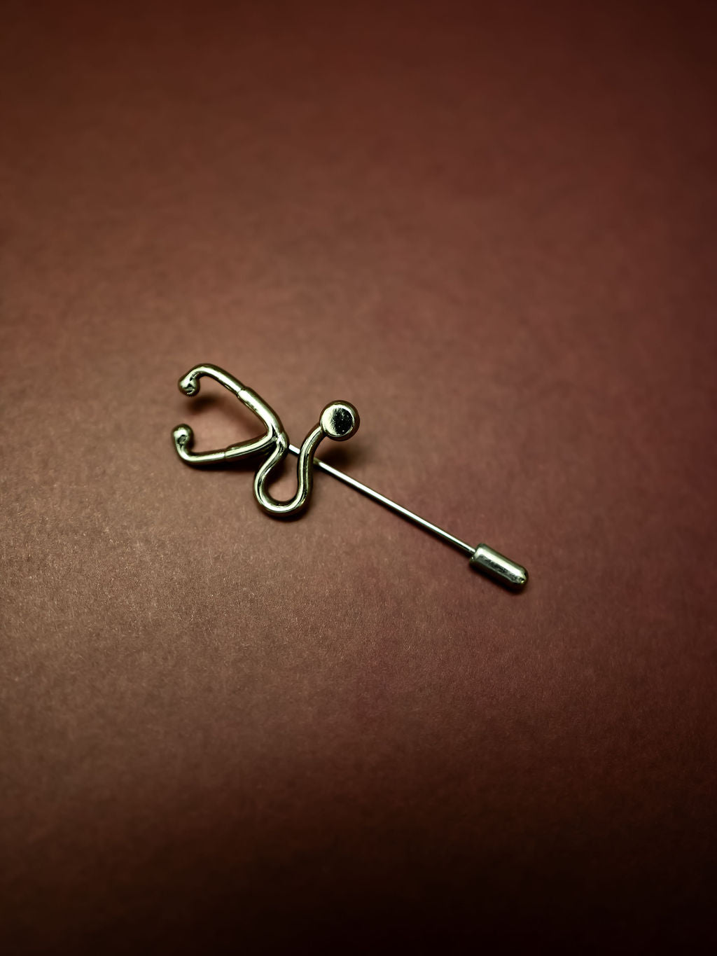 Silver Stethoscope Jacket Lapel Pin on burgundy background