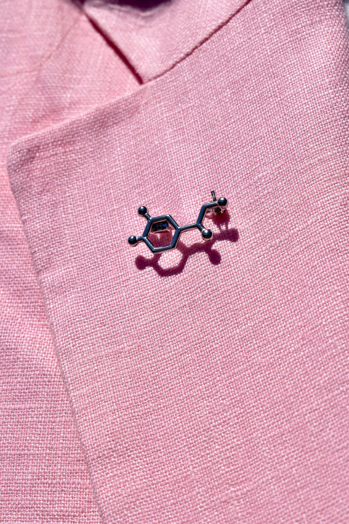 Close up of Dr. Beachgem Noradrenaline Molecule Lapel Pin on pink lapel
