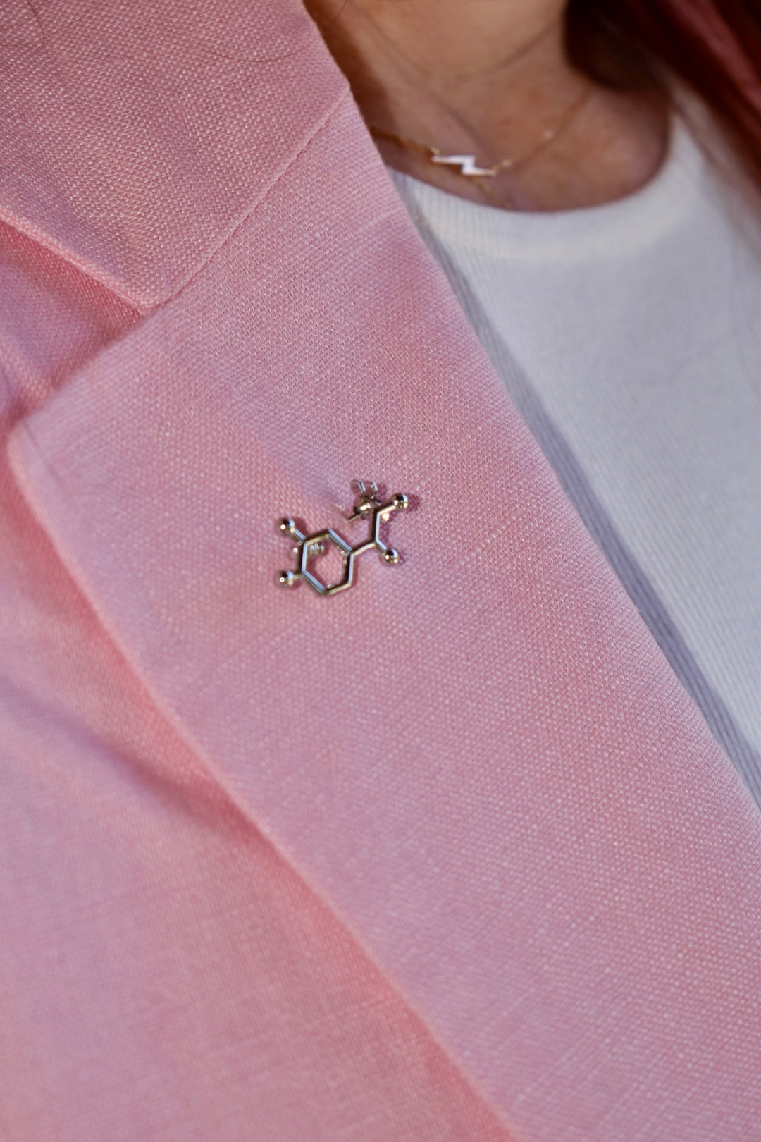 Ladyspinedoc wearing pink blazer with a silver Dr. Beachgem Noradrenaline Molecule Lapel Pin