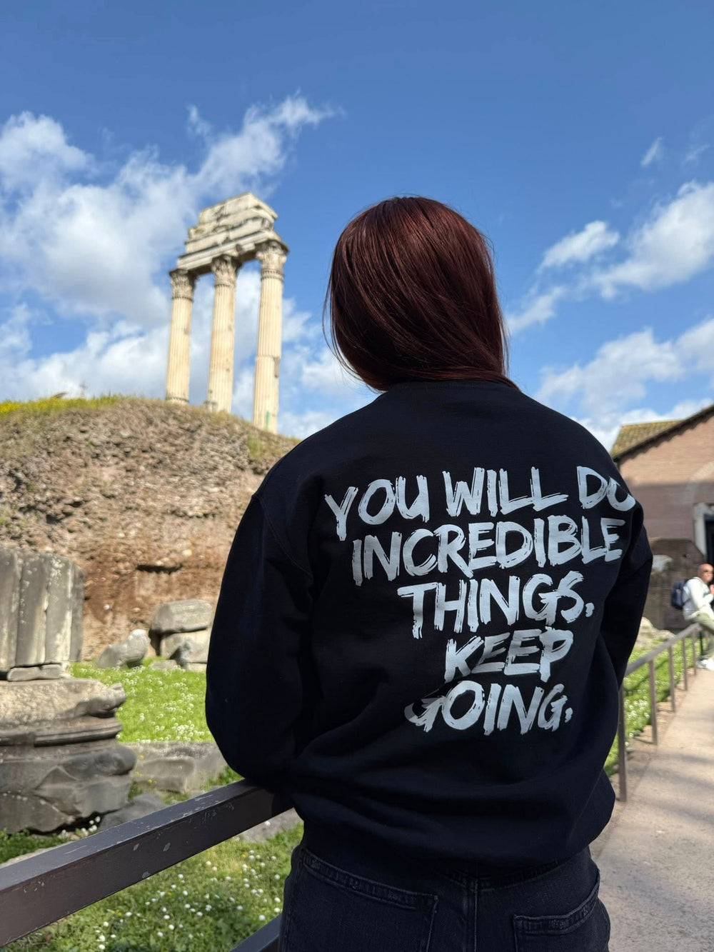 Ladyspinedoc in Rome, Italy showing the back of the Incredible Sweatshirt showcasing the motivational motto "YOU WILL DO INCREDIBLE THINGS. KEEP GOING." 