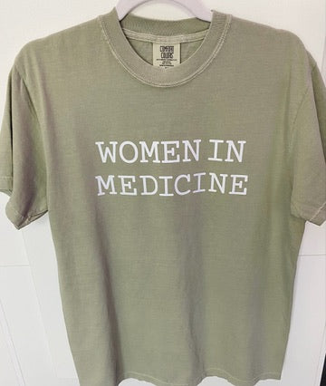 Green t-shirt with 'WOMEN IN MEDICINE' text on a white background
