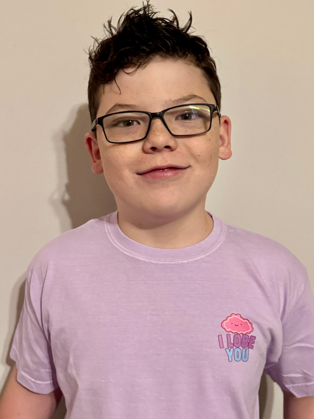 Boy showing off the front of the "I Lobe You" Brain Anatomy Tee with cartoon brain
