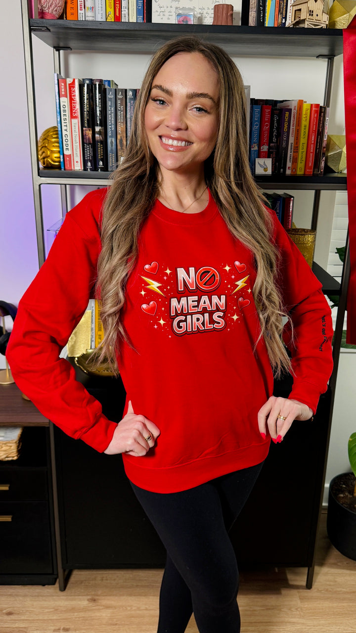 Dr. Brain Barbie wearing a red No Mean Girls sweatshirt in front of a bookcase