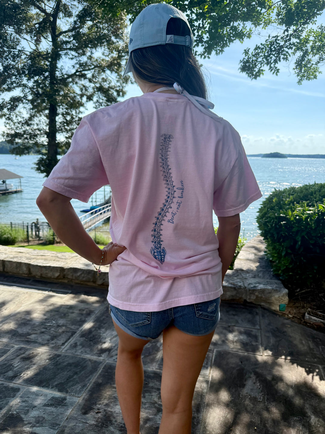 Model showing off the back spine design of the Bent, Not Broken Scoliosis Awareness Tee - Pink Cotton T-Shirt Short Sleeve