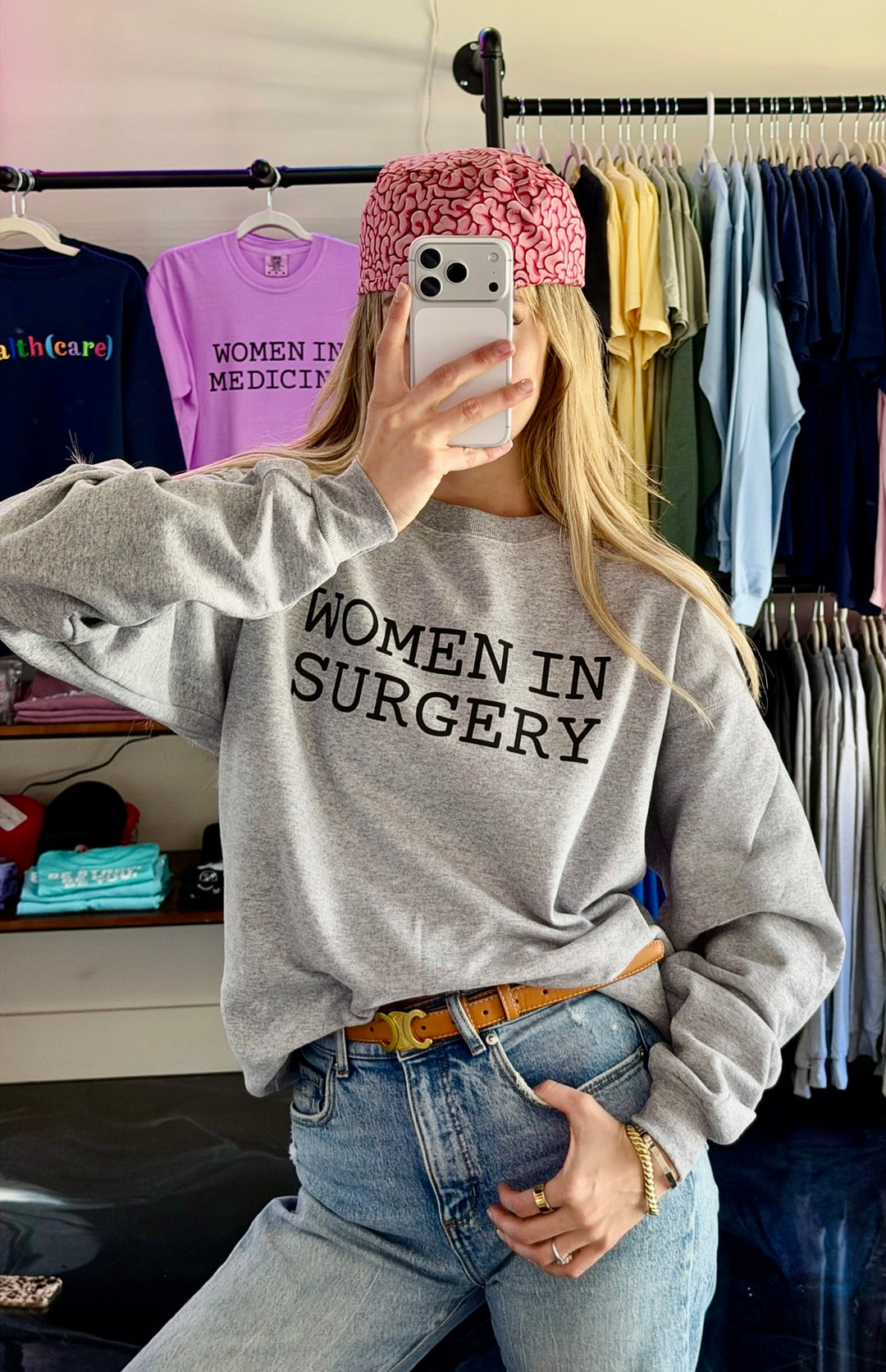 Person wearing a 'Women in Surgery' sweatshirt in a clothing store.