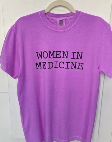 Purple t-shirt with 'WOMEN IN MEDICINE' text on a white background