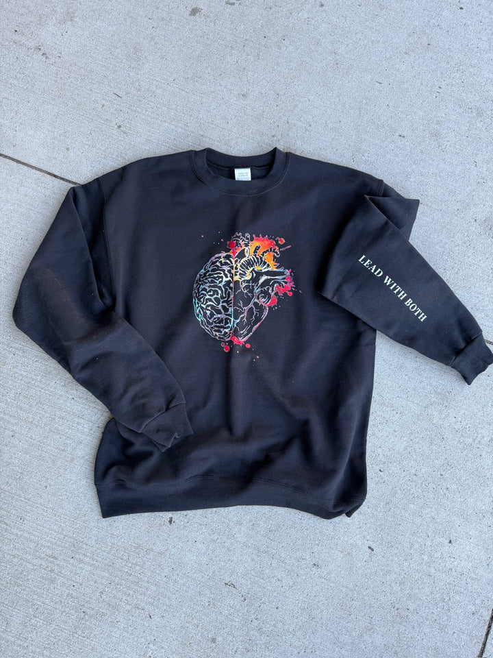 Flat lay of Synapse and Soul Crewneck Sweatshirt - Black Shirt with Half Brain,  Half Heart Design and "Lead With Both" Motto on sleeve