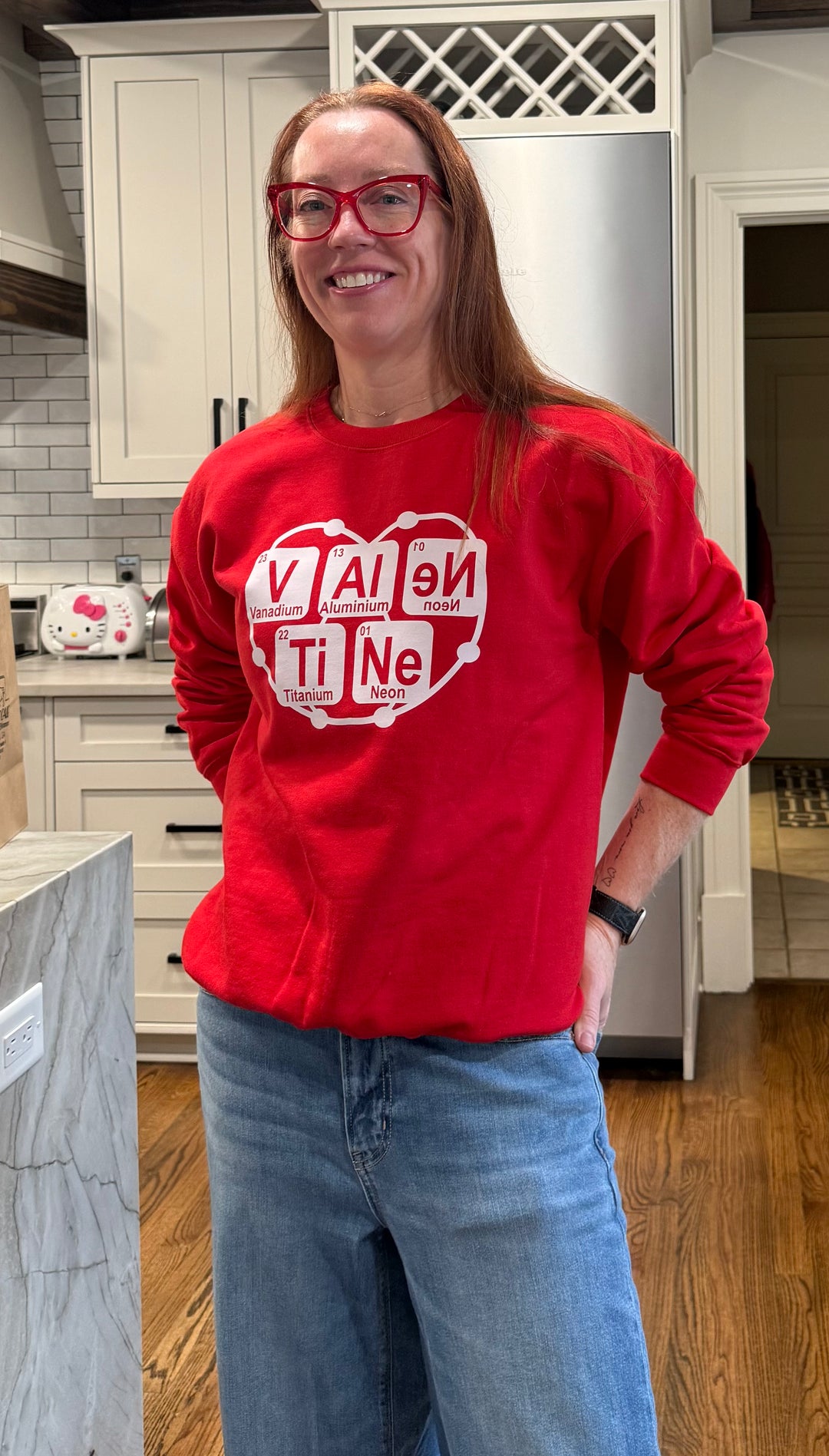 Dr. Betsy Grunch wearing the red Atomic Attraction crewneck sweatshirt with baggy jeans
