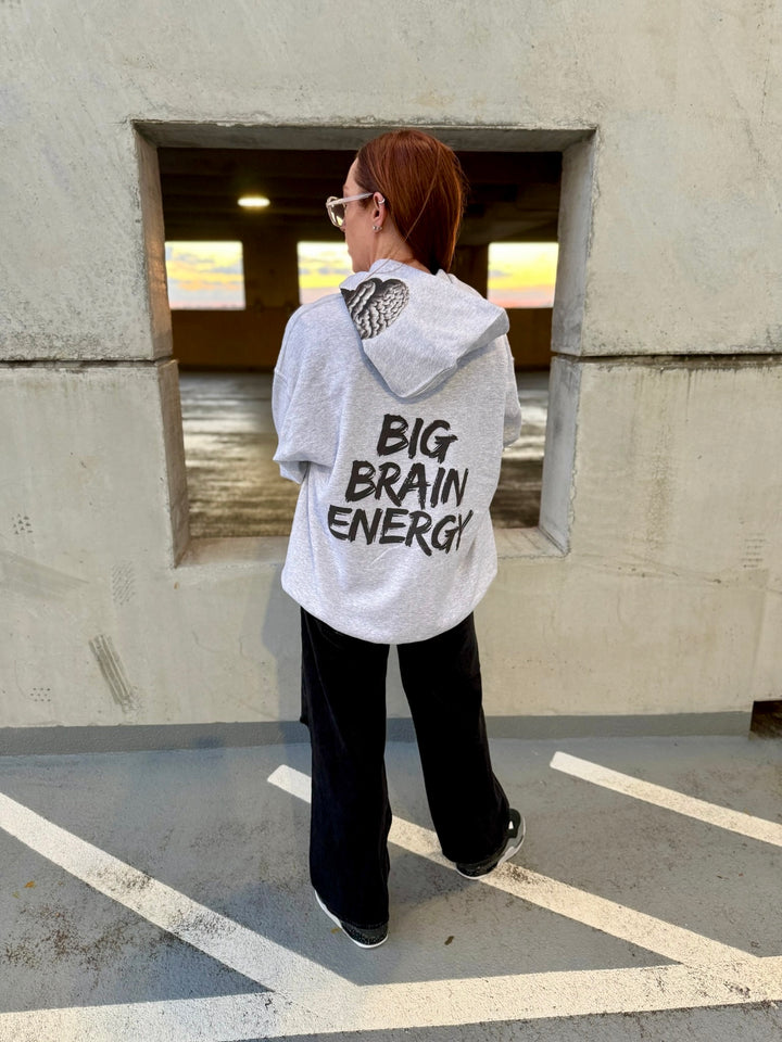 Dr. Betsy Grunch - Ladyspinedoc wearing a light gray hoodie that says "BIG BRAIN ENERGY" in bold black capital letters on the back and shows the brain design on the left side of the hood. 
