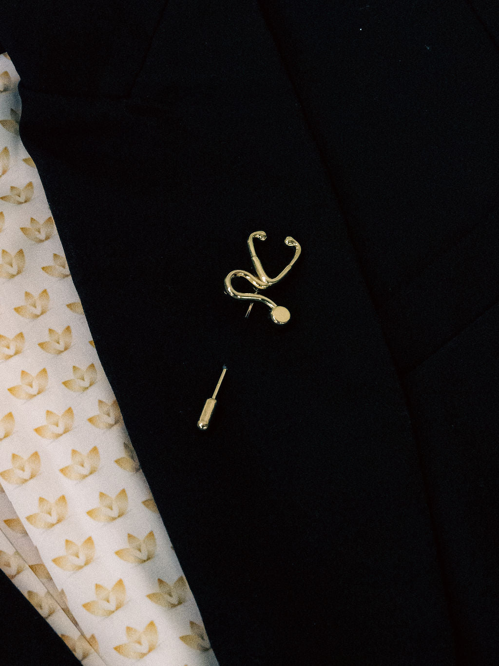 Stethoscope stick pin on a black jacket lapel