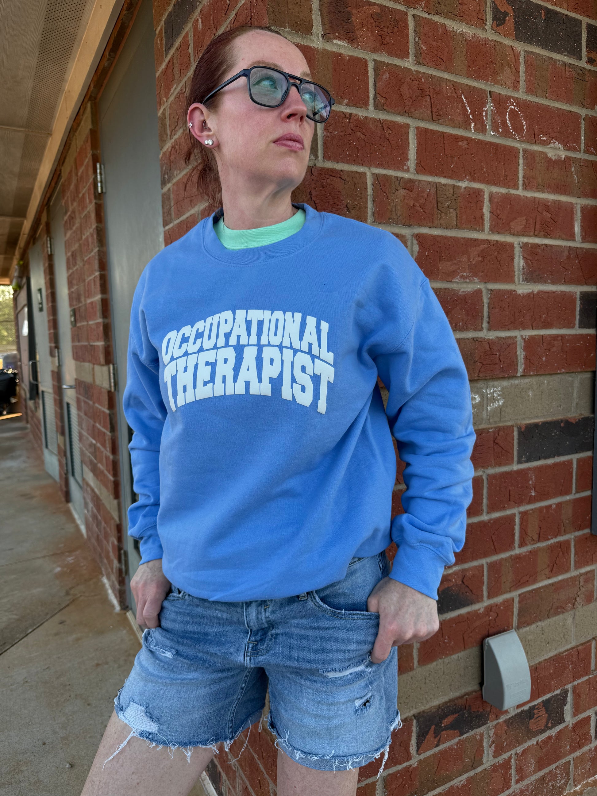 Dr. Betsy Grunch (Ladyspinedoc) modeling her blue Occupational Therapist sweatshirt. 