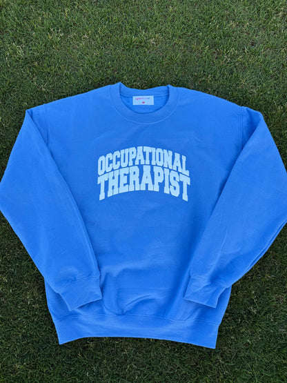 Flat lay of the blue Occupational Therapist crewneck sweatshirt designed by Ladyspinedoc (Dr. Betsy Grunch)