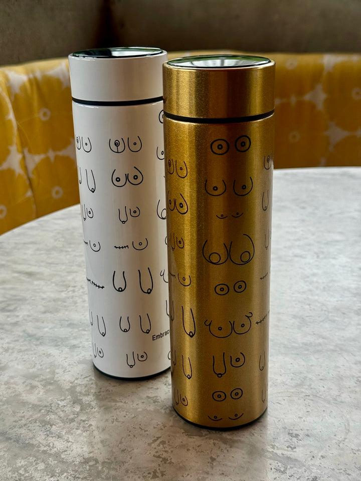 White and Gold Bosom Smart Water Bottles with Breast Design on table