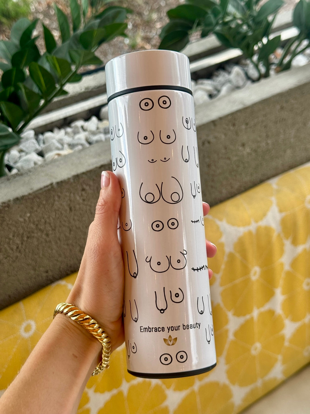 Person holding white Bosom Smart Water Bottle with Breast Design and LED Temperature Display