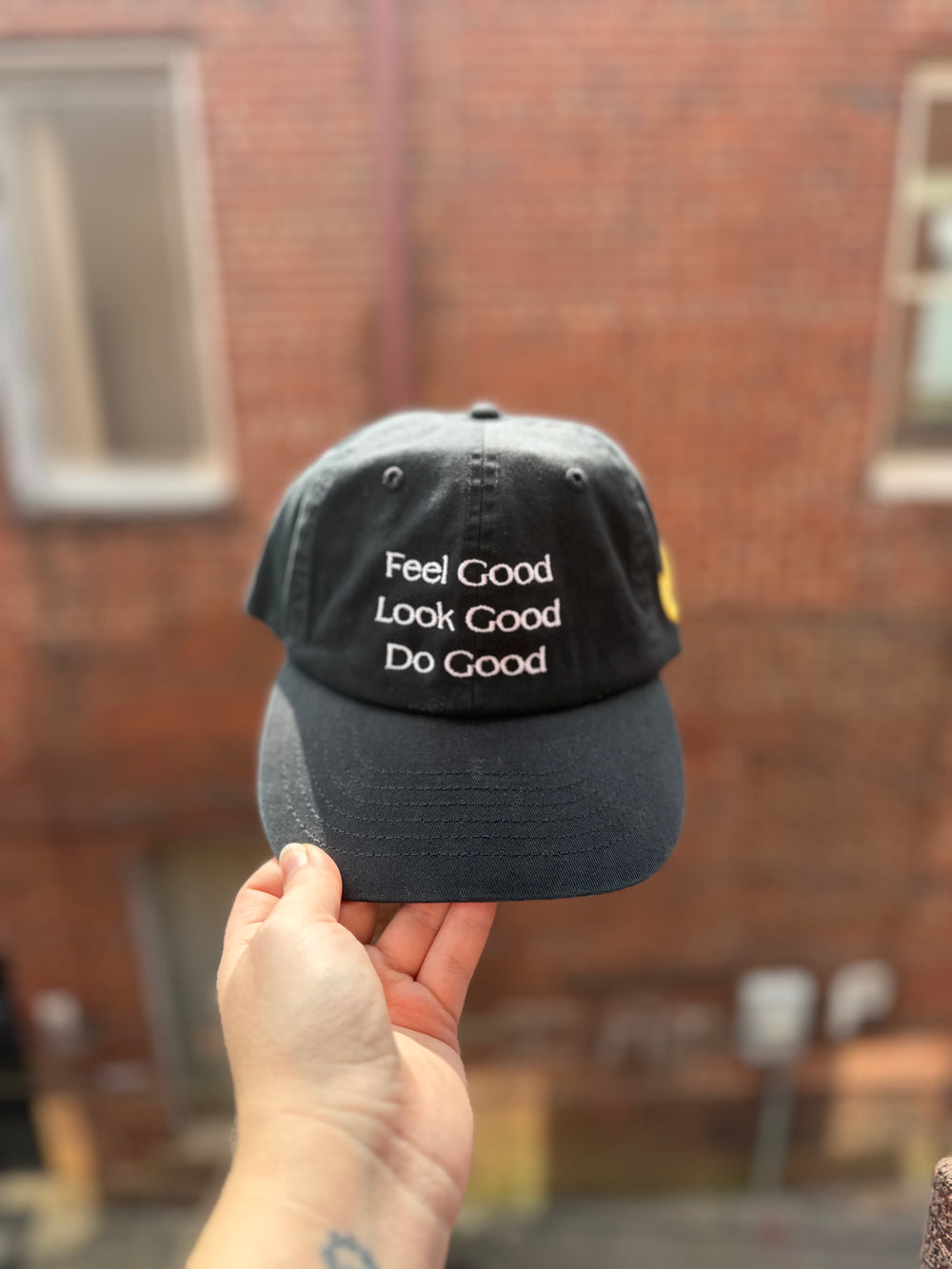 Black cotton baseball cap with white embroidered motto “Feel Good, Look Good, Do Good” on the front, from the Ladyspinedoc x Confidence Doc collab.